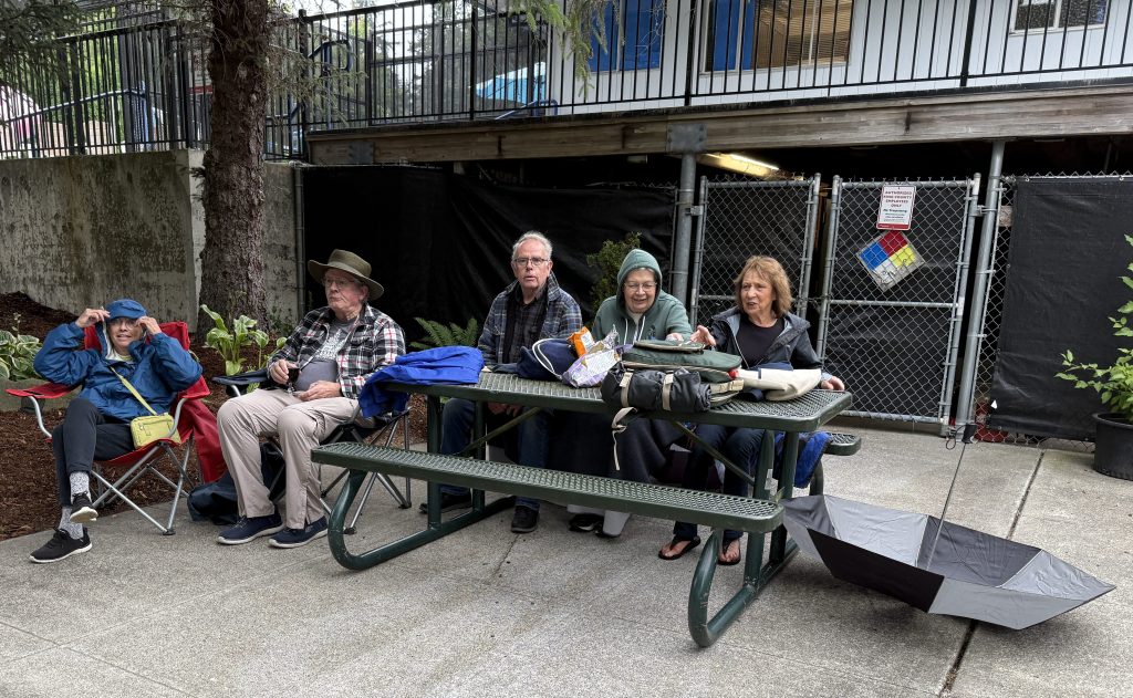 Friends gathering at the table to enjoy the 7/16/26 Music in the Park concert