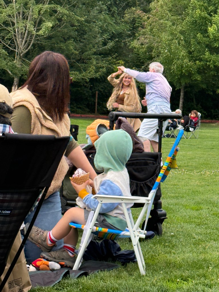 Child with ice cream and mother watching the dancers at 7/16/26 Music in the Park